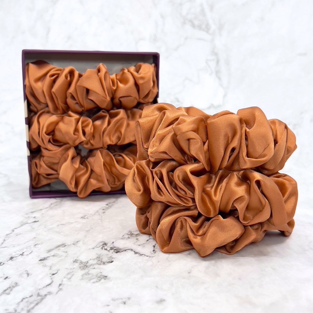 Silk Scrunchies - Copper by Mulberry Park Silks: A box of oversized rust-orange silk scrunchies, ideal for preventing hair damage and maintaining healthy, beautiful hair.