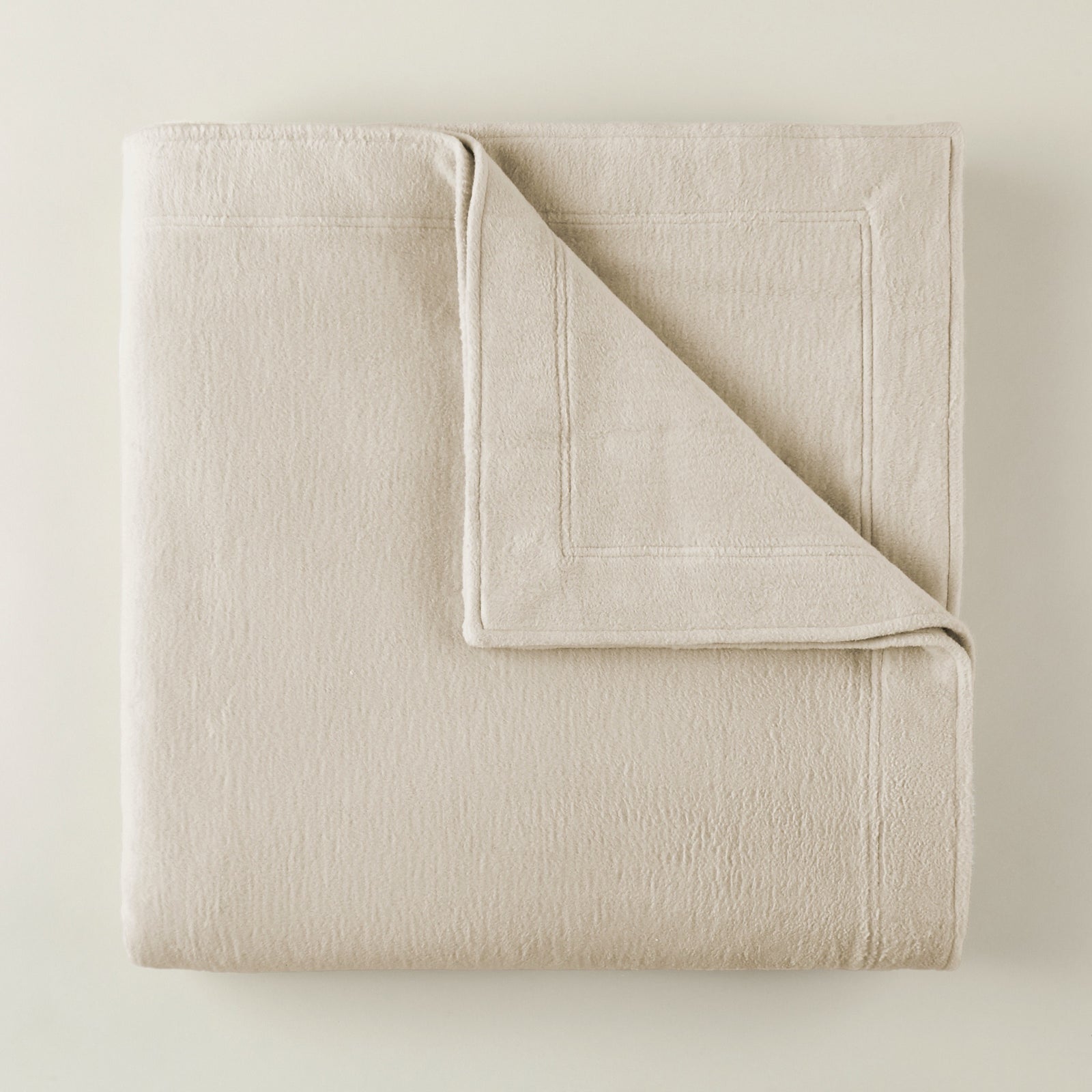 Folded Peacock Alley All Seasons Framed Blanket in Natural color