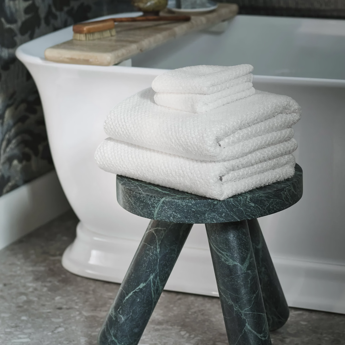 Peacock Alley Catalina Bath Towels beside a tub