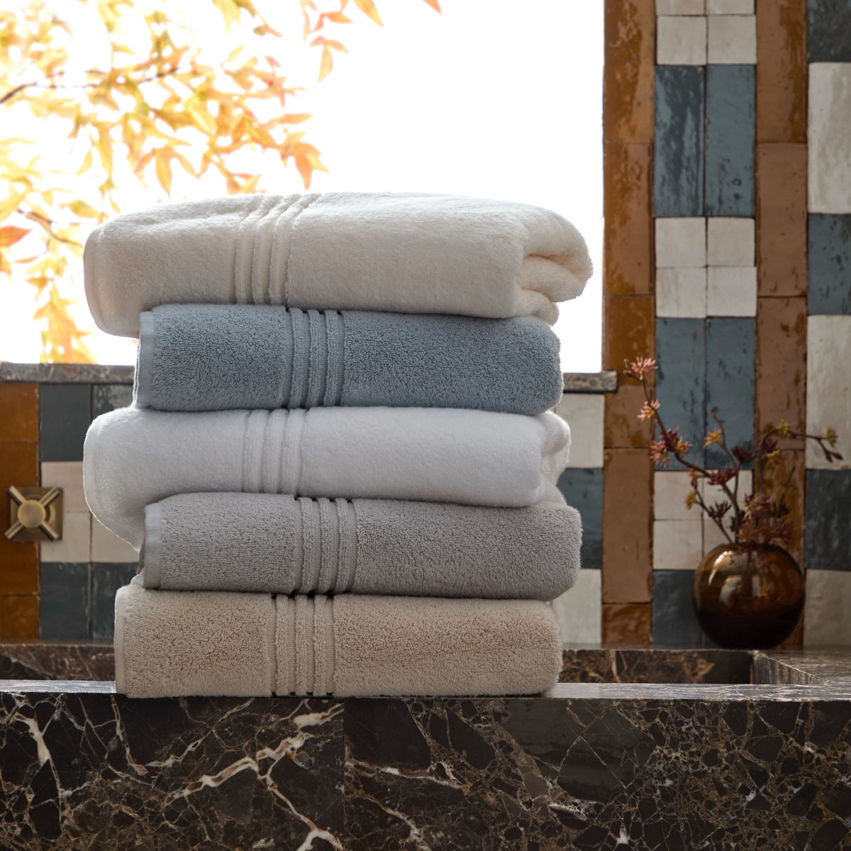 Stack of Peacock Alley Chelsea Bath Towels on a marble surface
