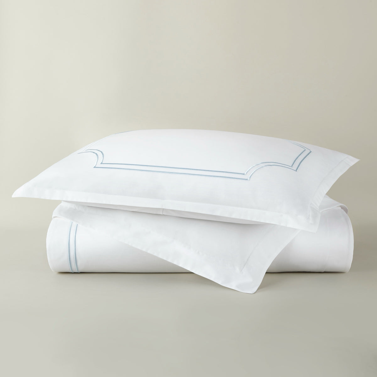 Stack of Peacock Alley Deco Classic Embroidered Duvet Set in Sky color