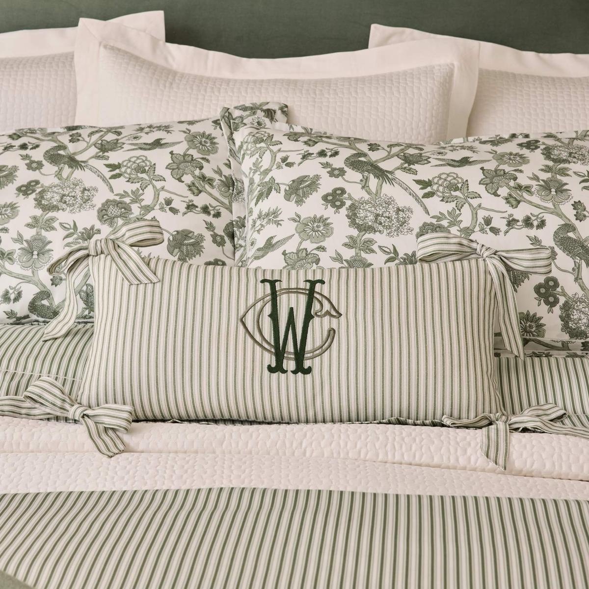 Moss colored Peacock Alley Oblong Bow Pillow in the middle of a bed