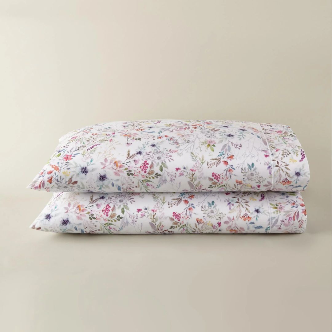 Stack of floral-patterned pillows on a beige background