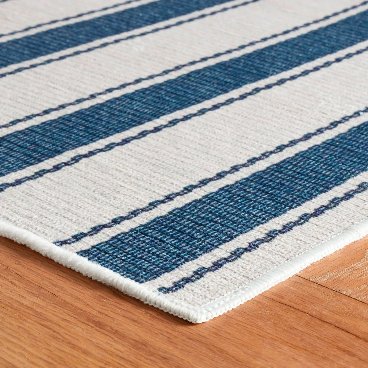 Corner of Blue Pine Cone Hill Awning Stripe Machine Washable Rug