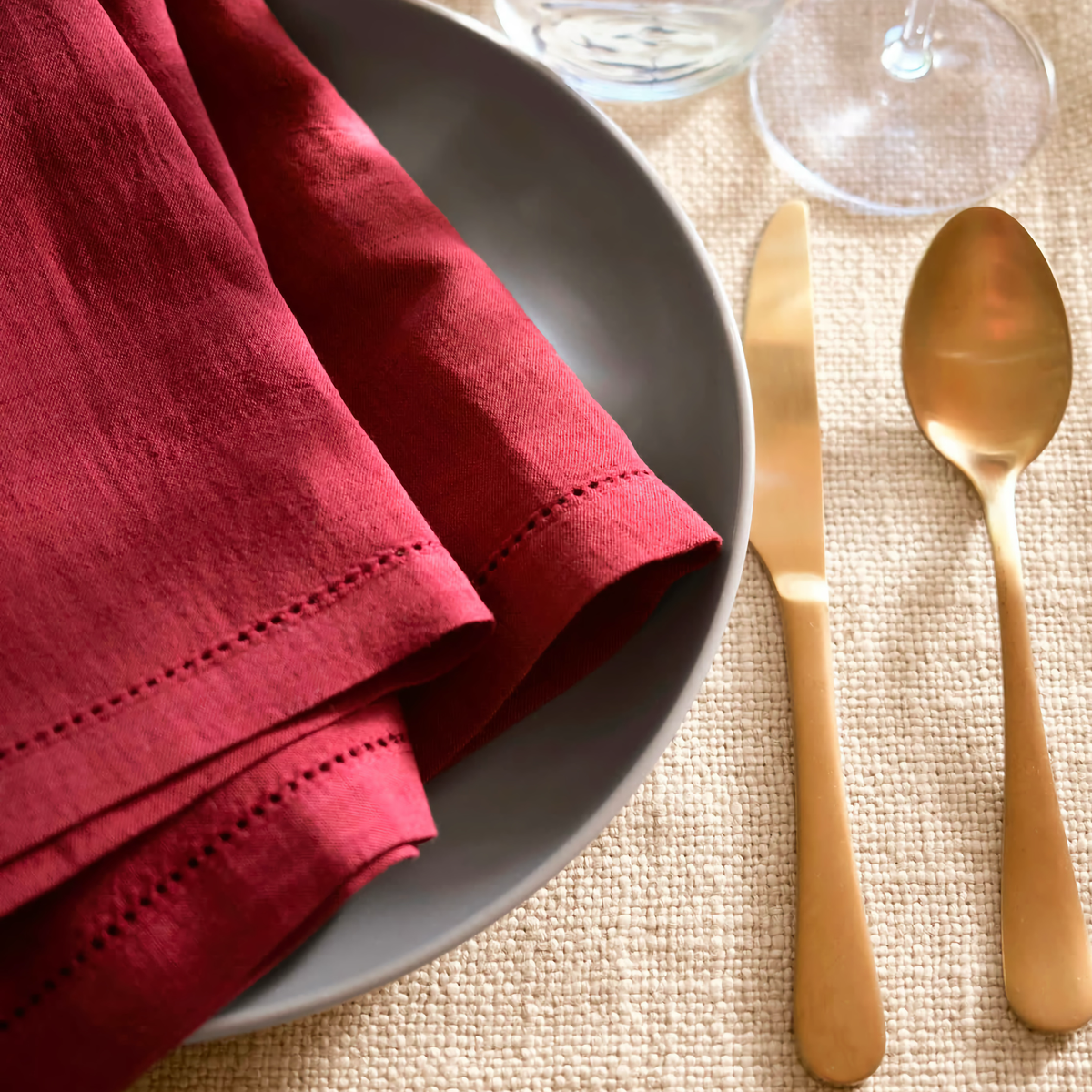 Pine Cone Hill Haven Hemstitch Napkin Set in Merlot on a Plate