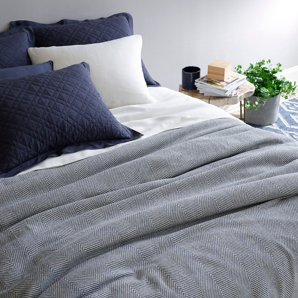 Bed with Pine Cone Hill Herringbone Blanket in Navy/Ivory Color