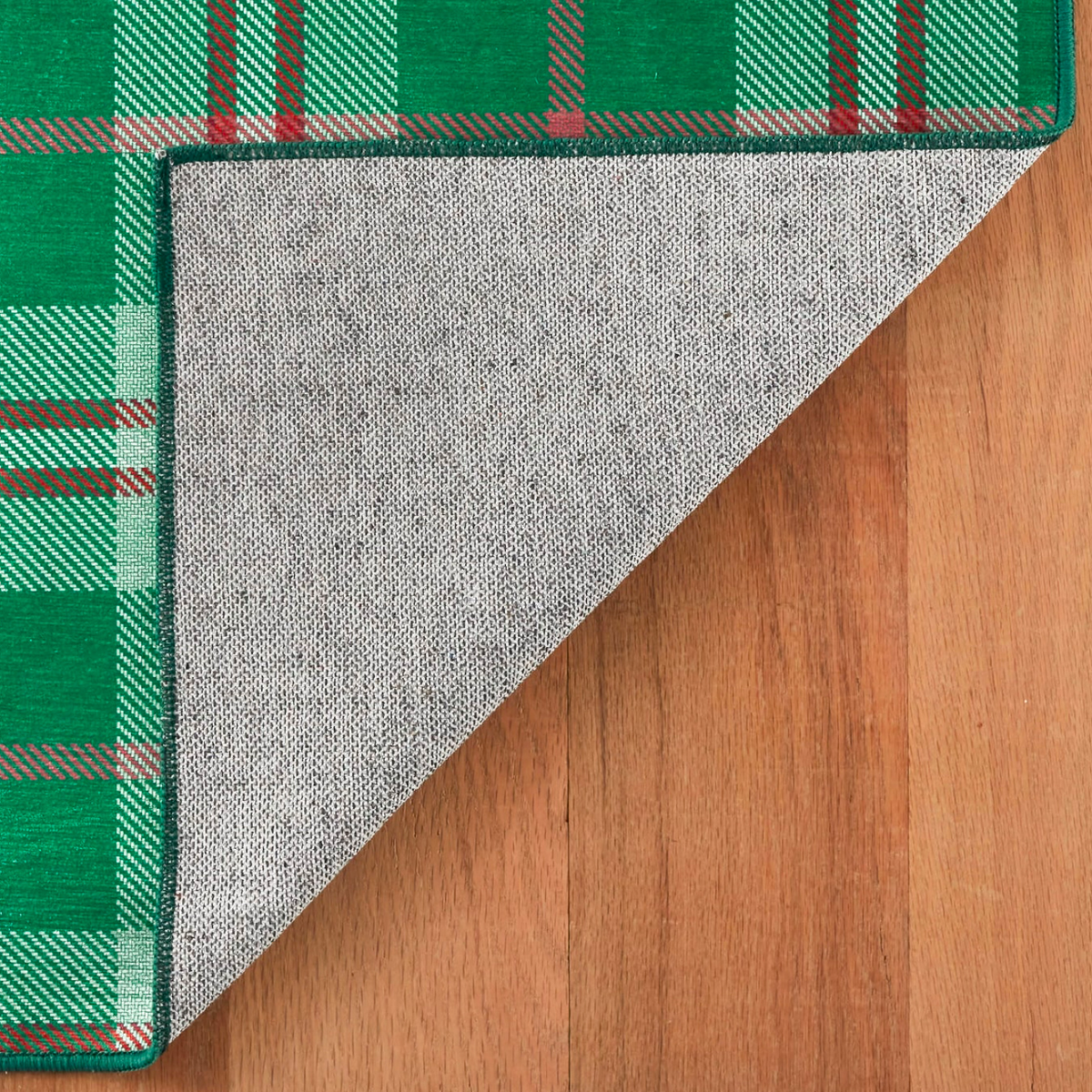 Folded Corner of Pine Cone Hill Jolly Plaid Machine Washable Rug in Green Color