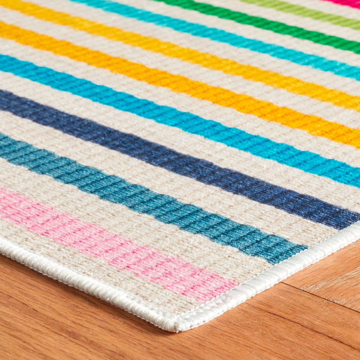 Corner View of Pine Cone Hill Rainbow Stripe Machine Washable Rug