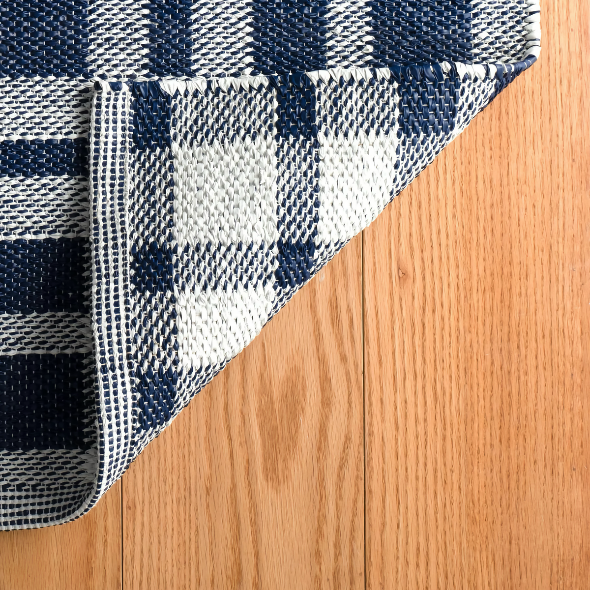 Folded Corner of Pine Cone Hill Tattersall Handwoven Indoor and Outdoor Rug in Navy