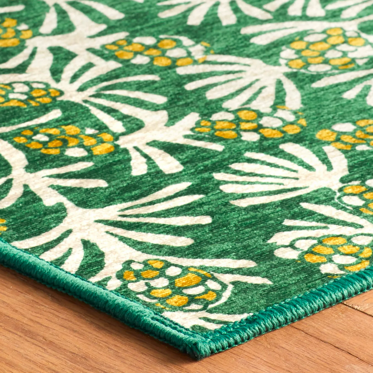 Closeup Detail of Pine Cone Hill Winter Pinecones Machine Washable Rug in Green Color on the Floor