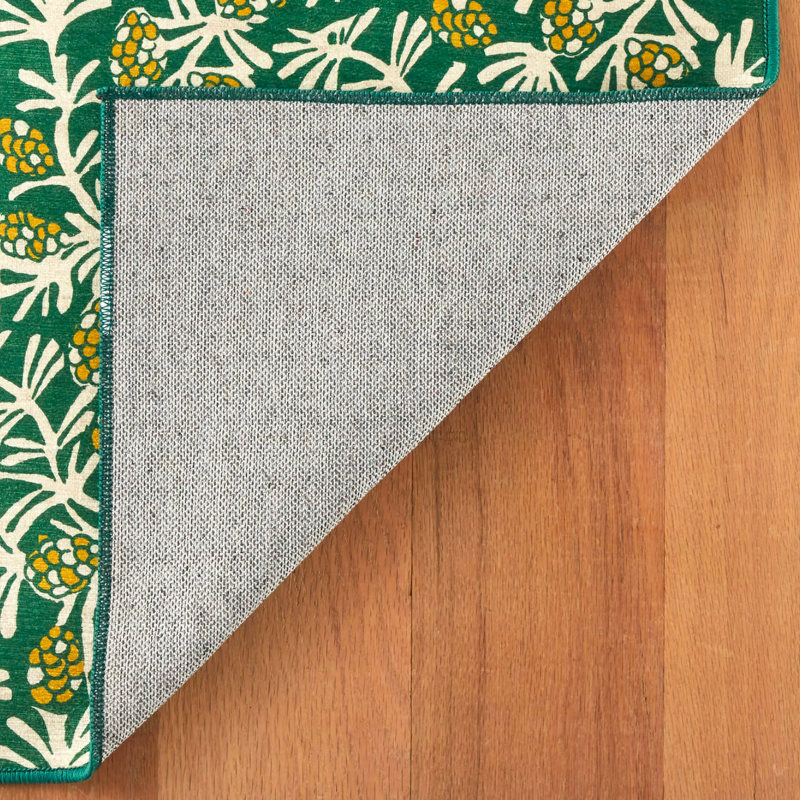 Lifestyle of Pine Cone Hill Winter Pinecones Machine Washable Rug in Green Color on the Floor