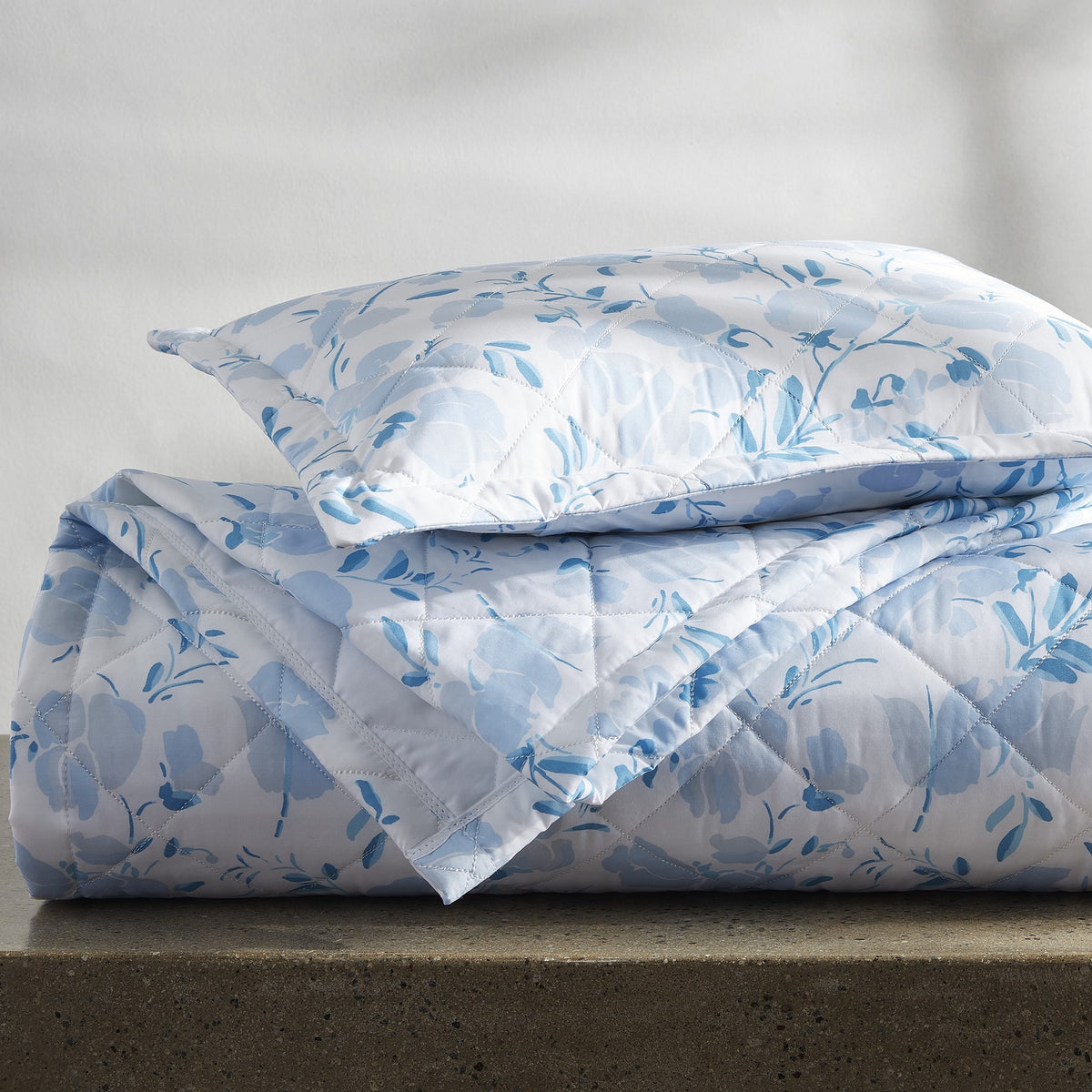 Folded Stack of Quilted Matouk Alexandra Bedding in Sky Color
