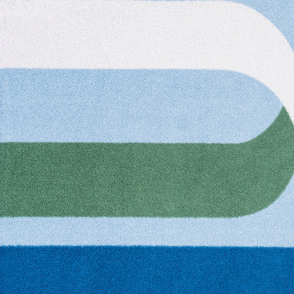 swatch of matouk ribbon beach towel in ocean