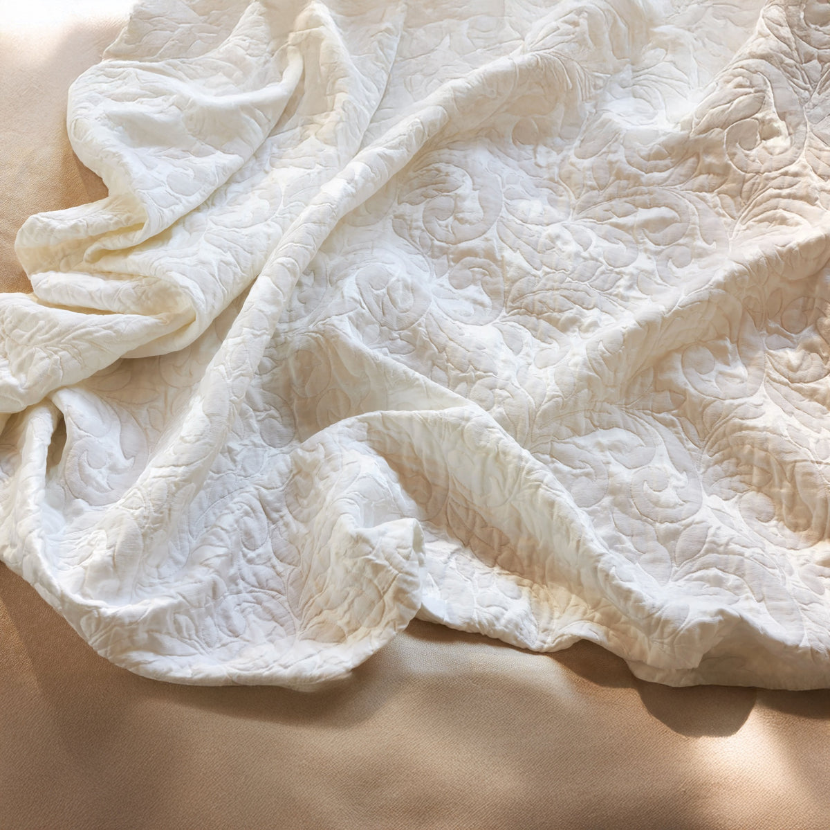 Jasmine Matelassé Snow coverlet on a bed