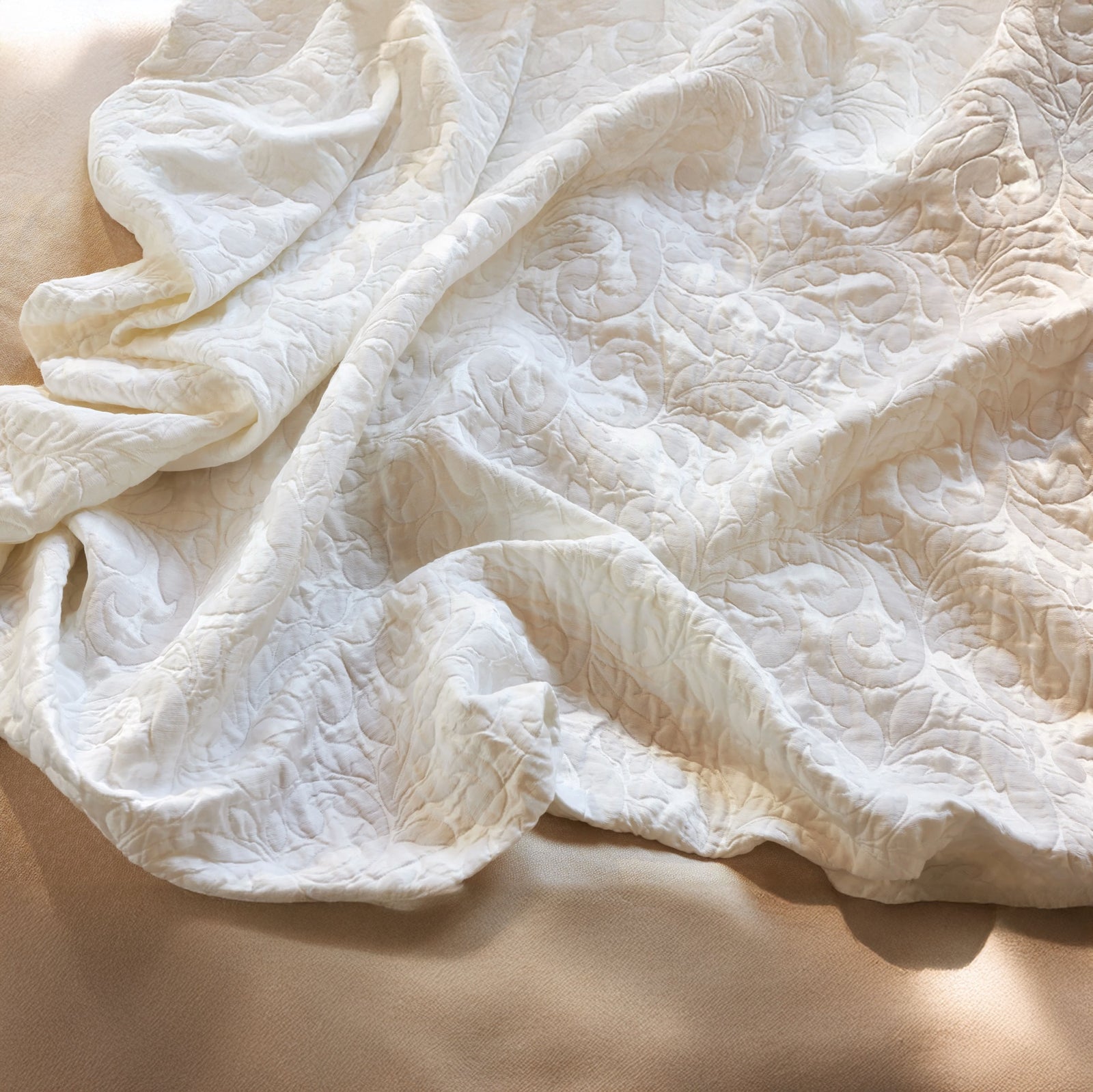 Jasmine Matelassé Snow coverlet on a bed