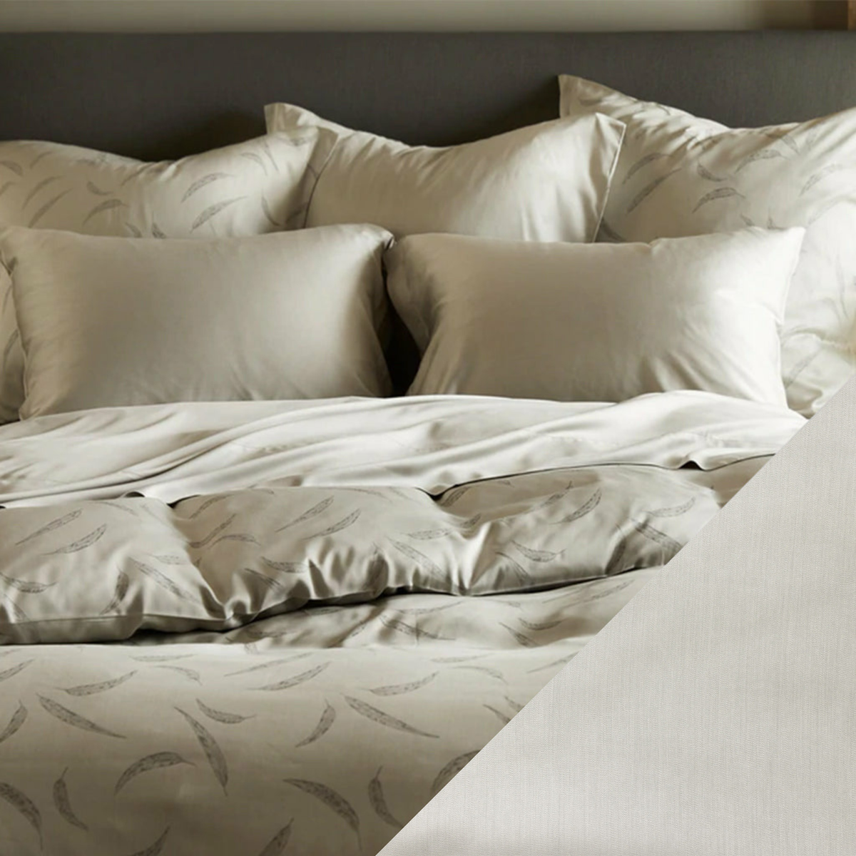 A neatly made bed with OEKO-TEX certified bedding, multiple pillows, and a subtle leaf pattern on the duvet cover.