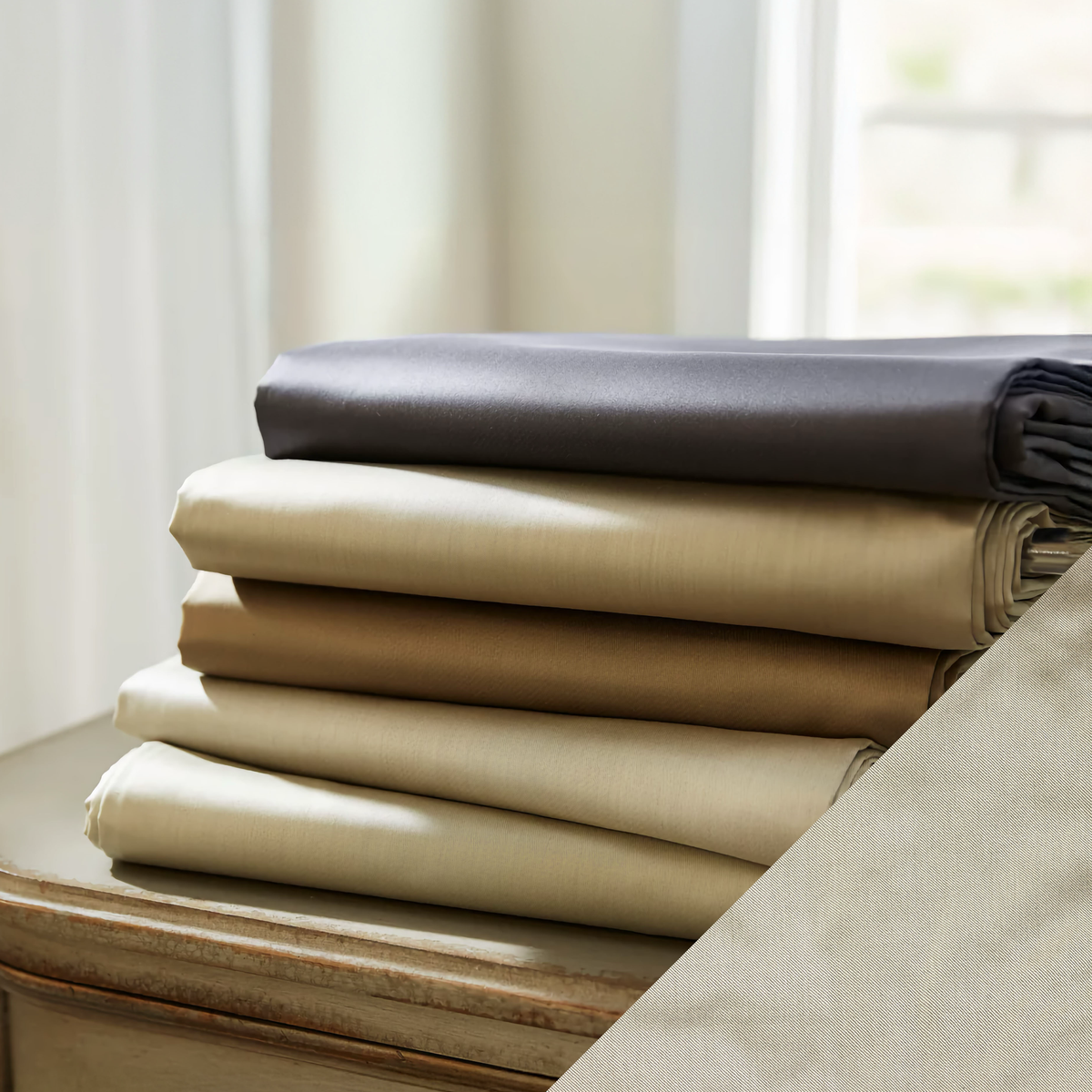 Stack of SDH Pavia Sateen Bedding with Pearl Swatch