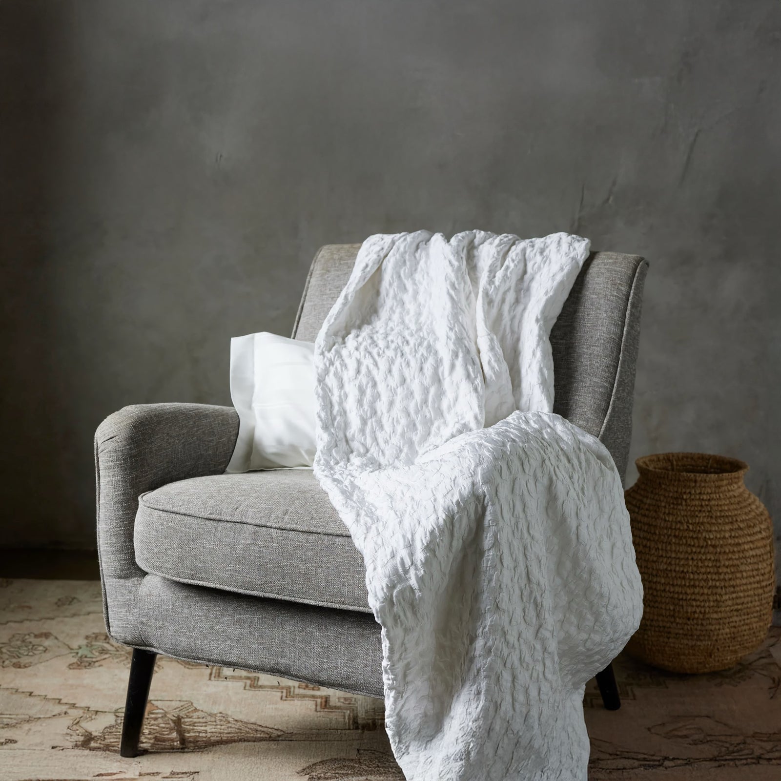 Snow SDH Petalo Bedding draped on a sofa