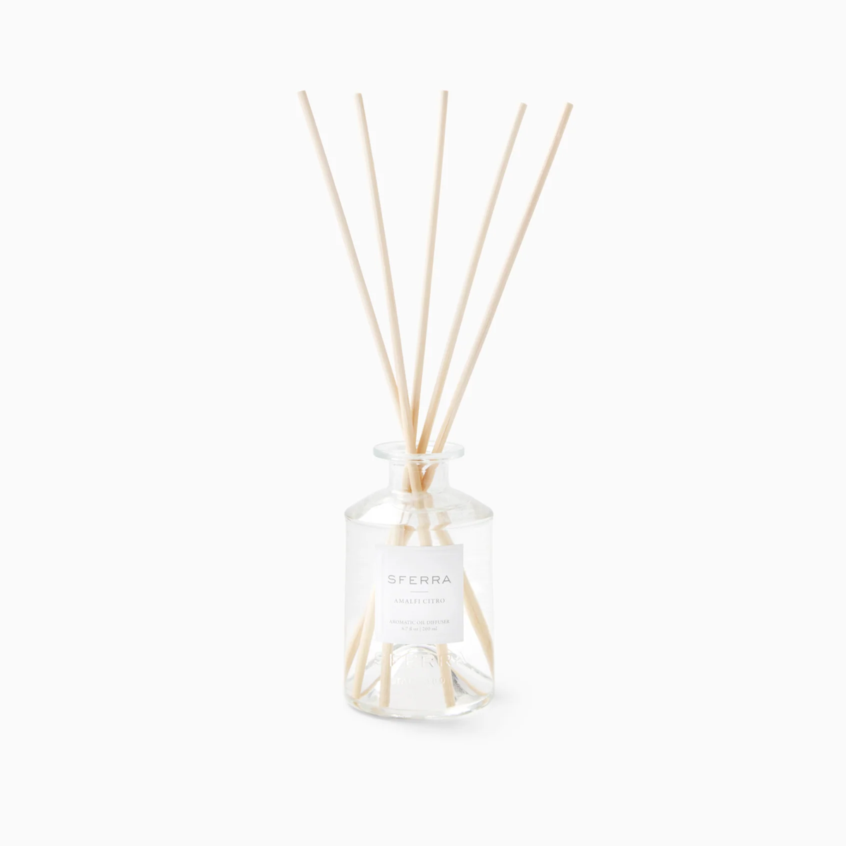Clear glass SFERRA home fragrance diffuser with natural reeds, evoking Italian-inspired home fragrances and elegance.