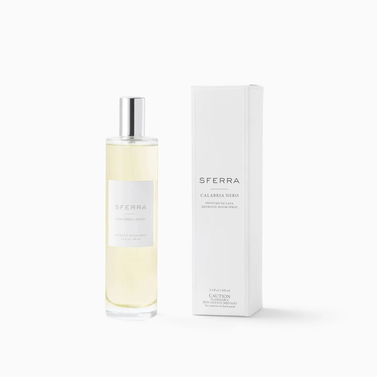 A clear bottle of SFERRA Calabria Nero room spray, part of Sferra Profumo di Casa luxury home scents, sits by its box.