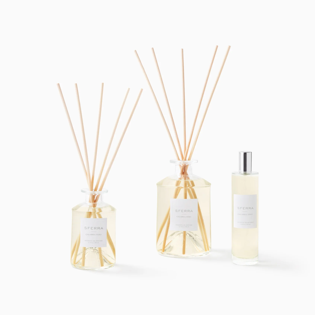 Three clear bottles of Sferra Profumo di Casa, Calabria Nero scents, with reed sticks displayed on a white background.