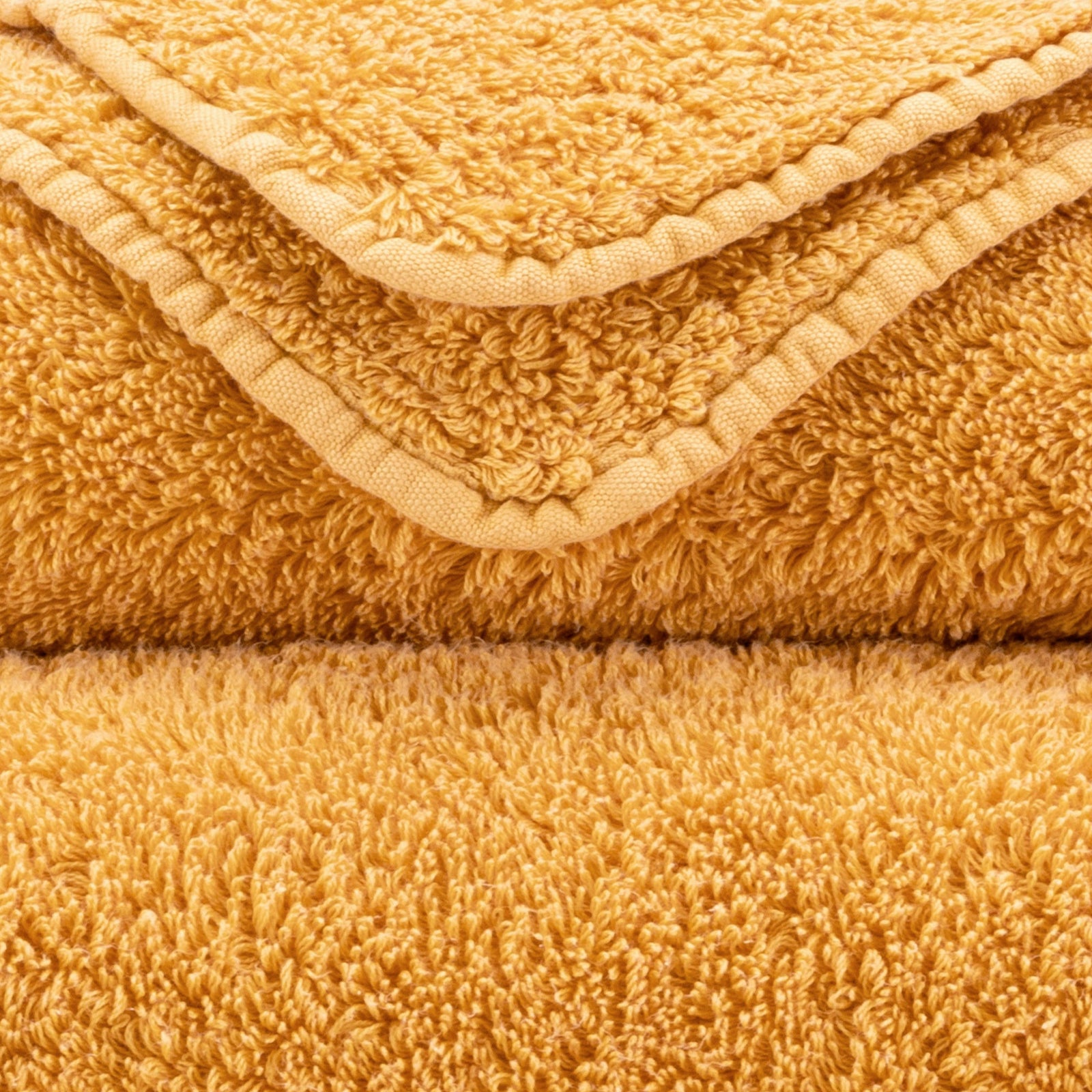 Stack of Abyss Super Pile Bath Towels in Curcuma Color
