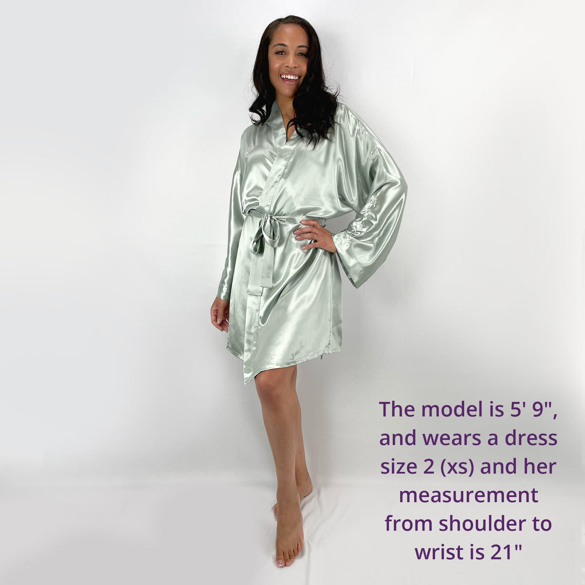 Woman standing in a front view, wearing a female robe, with measurements and size details displayed