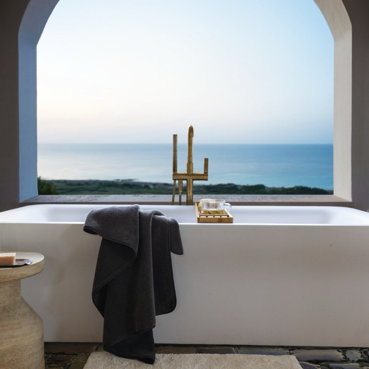 Bathroom with a Scandia Home Delfine Bath Towel on a bathtub and view of the ocean