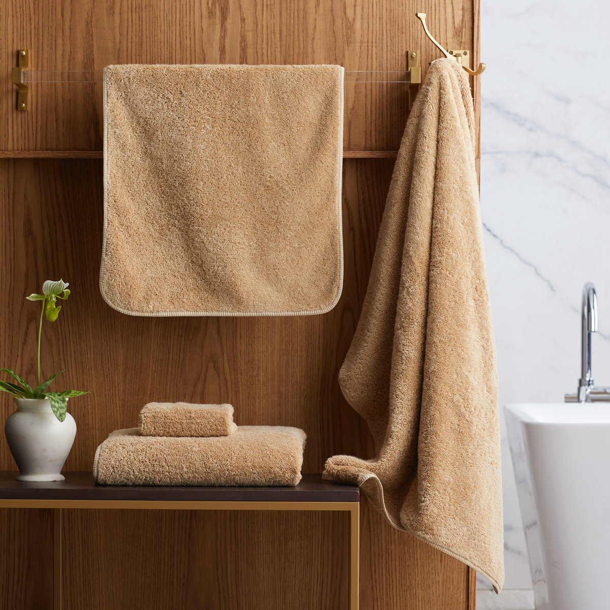 Bathroom with folded Bronze Scandia Home Indulgence Towels on a shelf and hanging on a towel rack