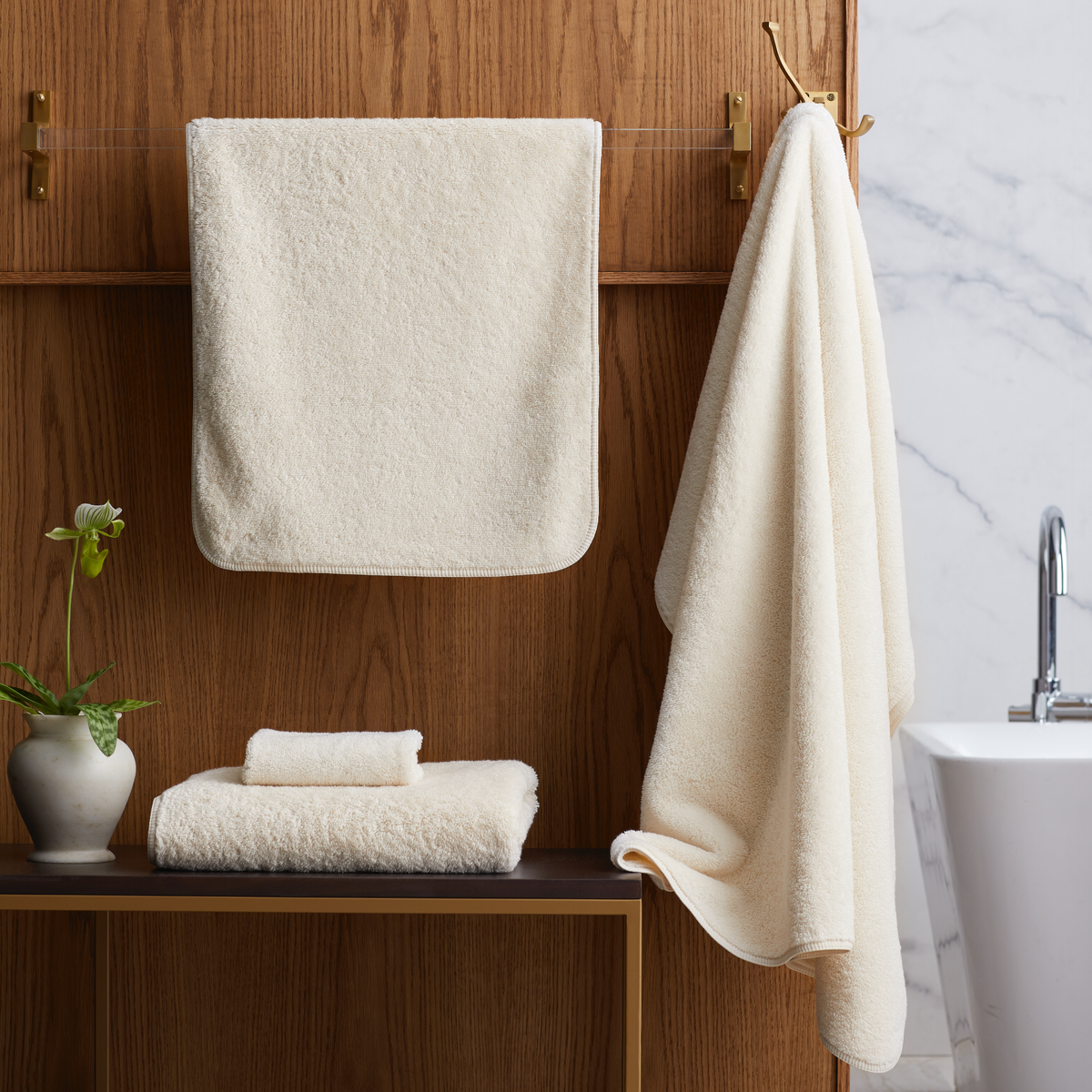 Bathroom with folded Ivory Scandia Home Indulgence Towels on a shelf and hanging on a towel rack