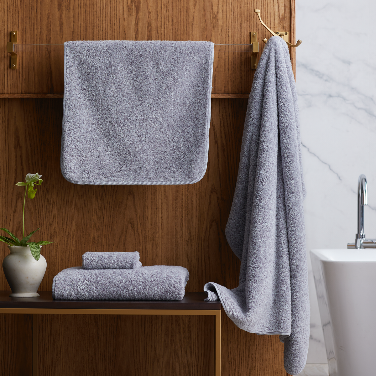 Bathroom with folded Silver Scandia Home Indulgence Towels on a shelf and hanging on a towel rack