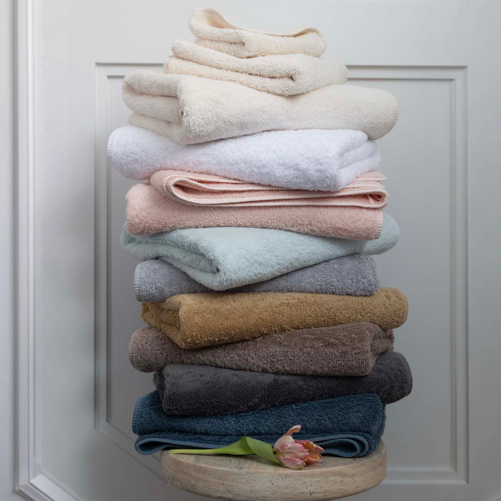 Stack of folded Scandia Home Indulgence Towel in 2025 colors on a wooden block against a white background