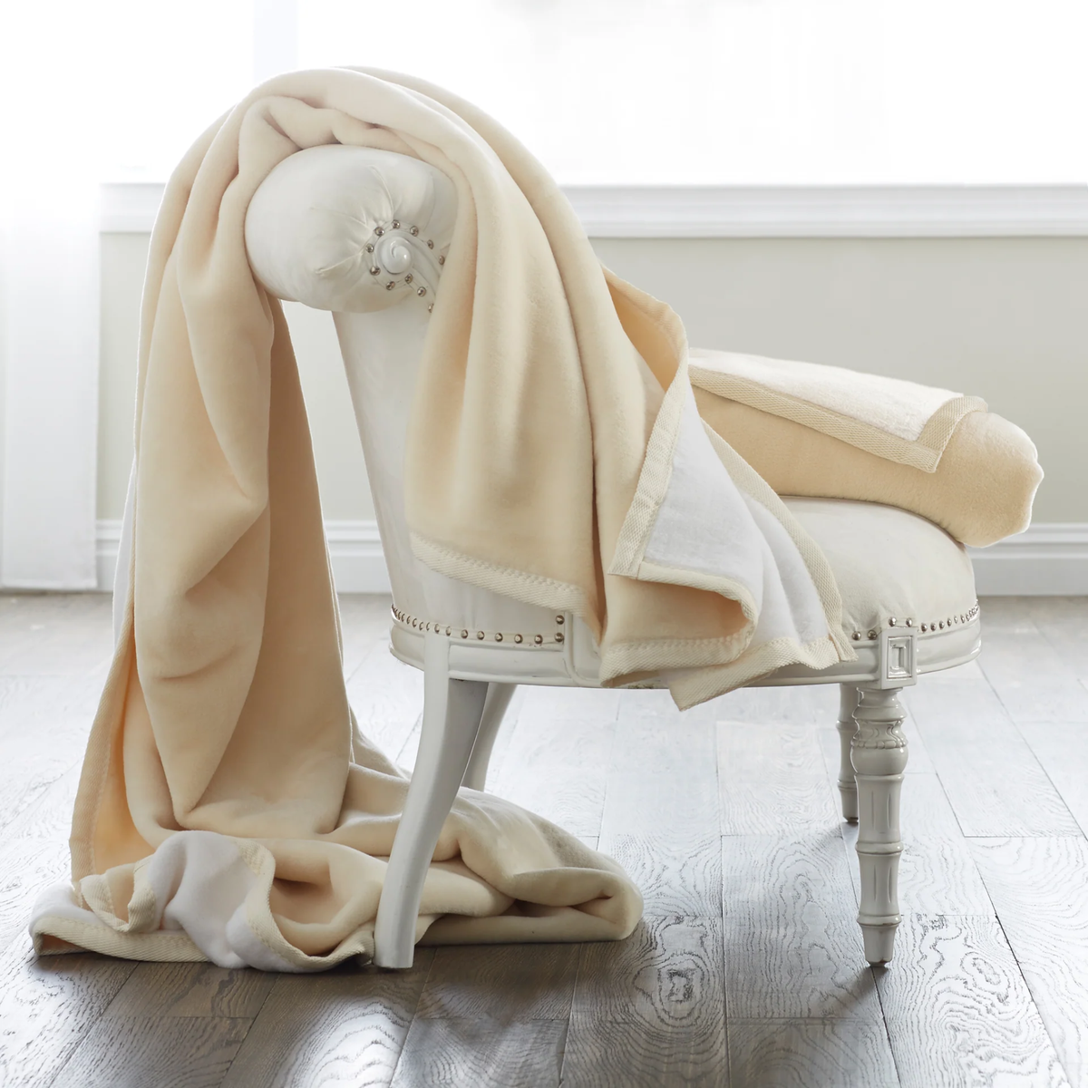 Scandia Home Reversible Plush Cotton Blanket in White and Cream on a chair