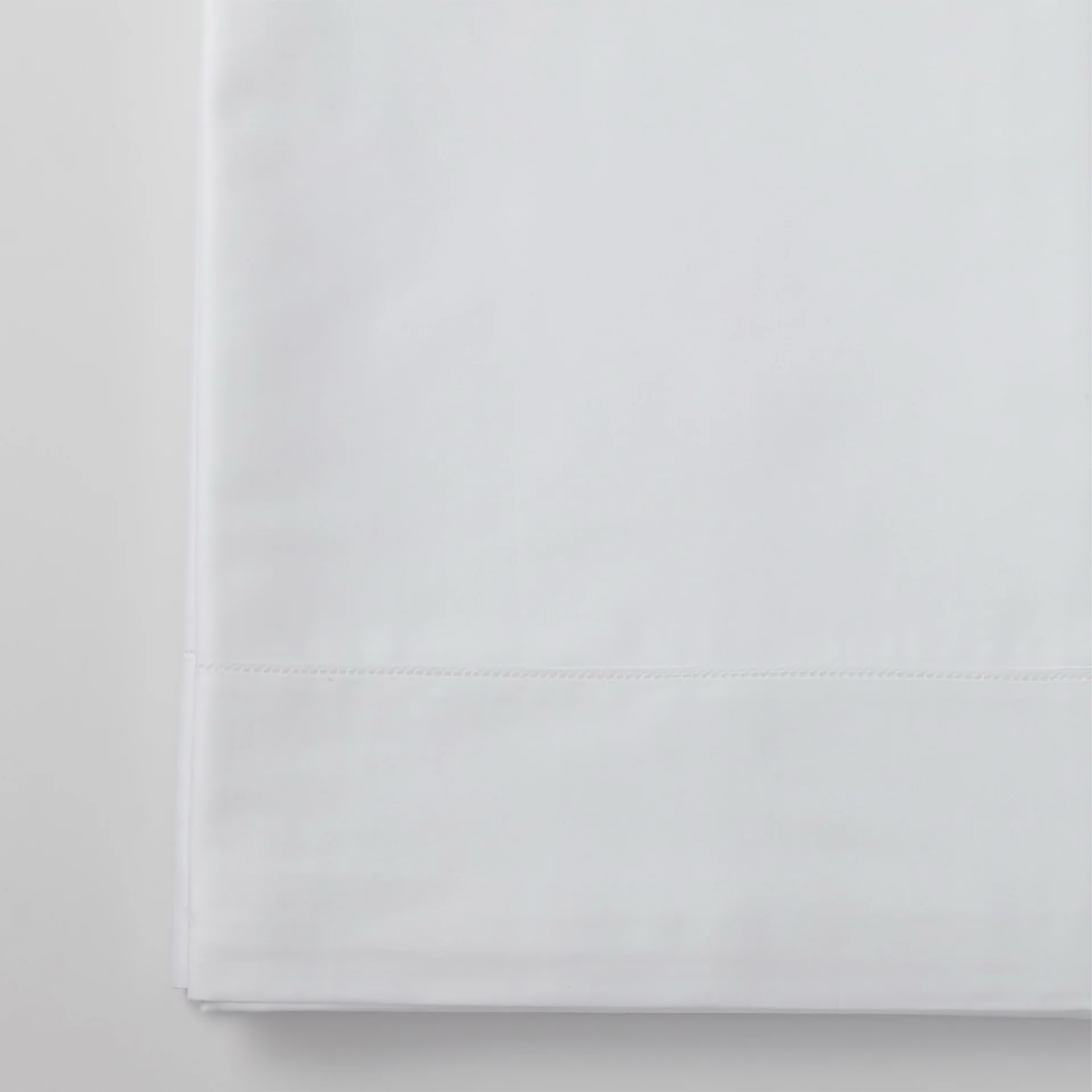 Woman standing by a four poster bed that is made with Scandia Home Stresa Bedding in White