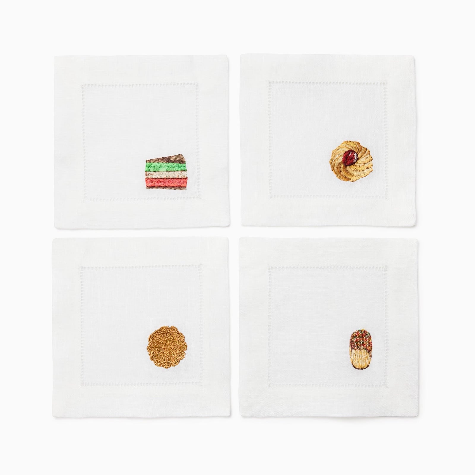 Sferra Biscotto cocktail napkins arranged around a plate of cookies and a cup of tea