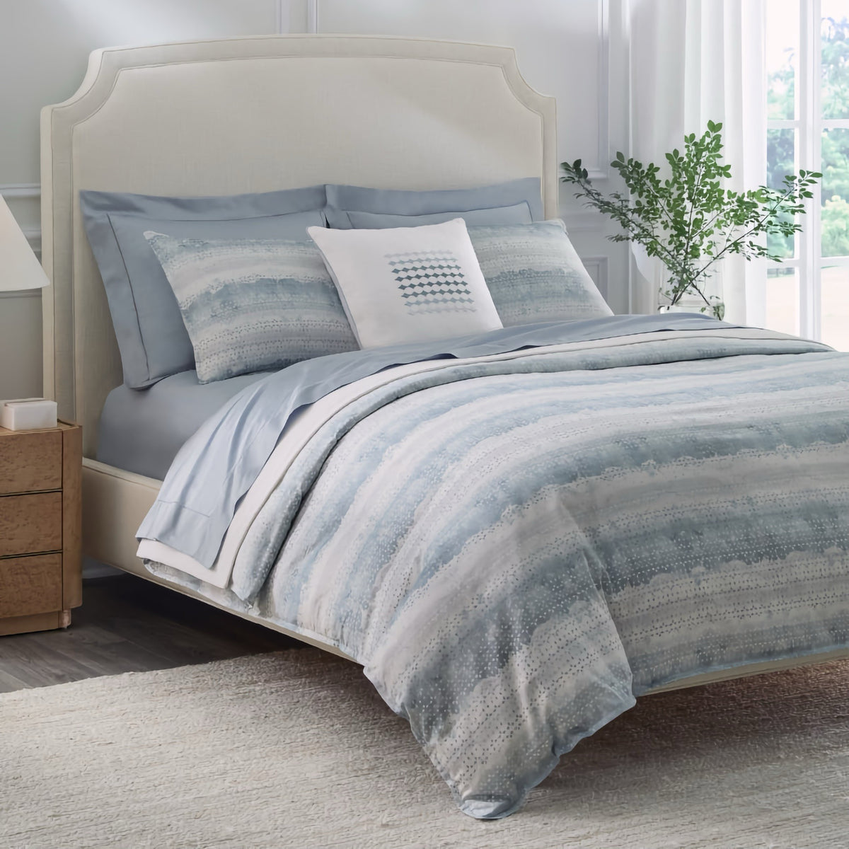 Corner view of Sferra Brillanti Duvet Cover and Shams in Sky color