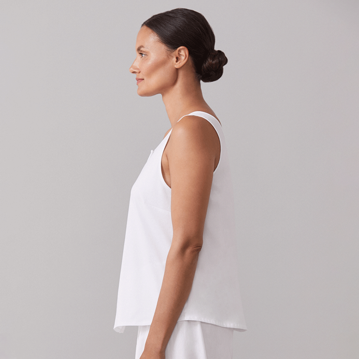 Sideview of Female Model Wearing a White Sferra Caricia Buttoned Tank Top