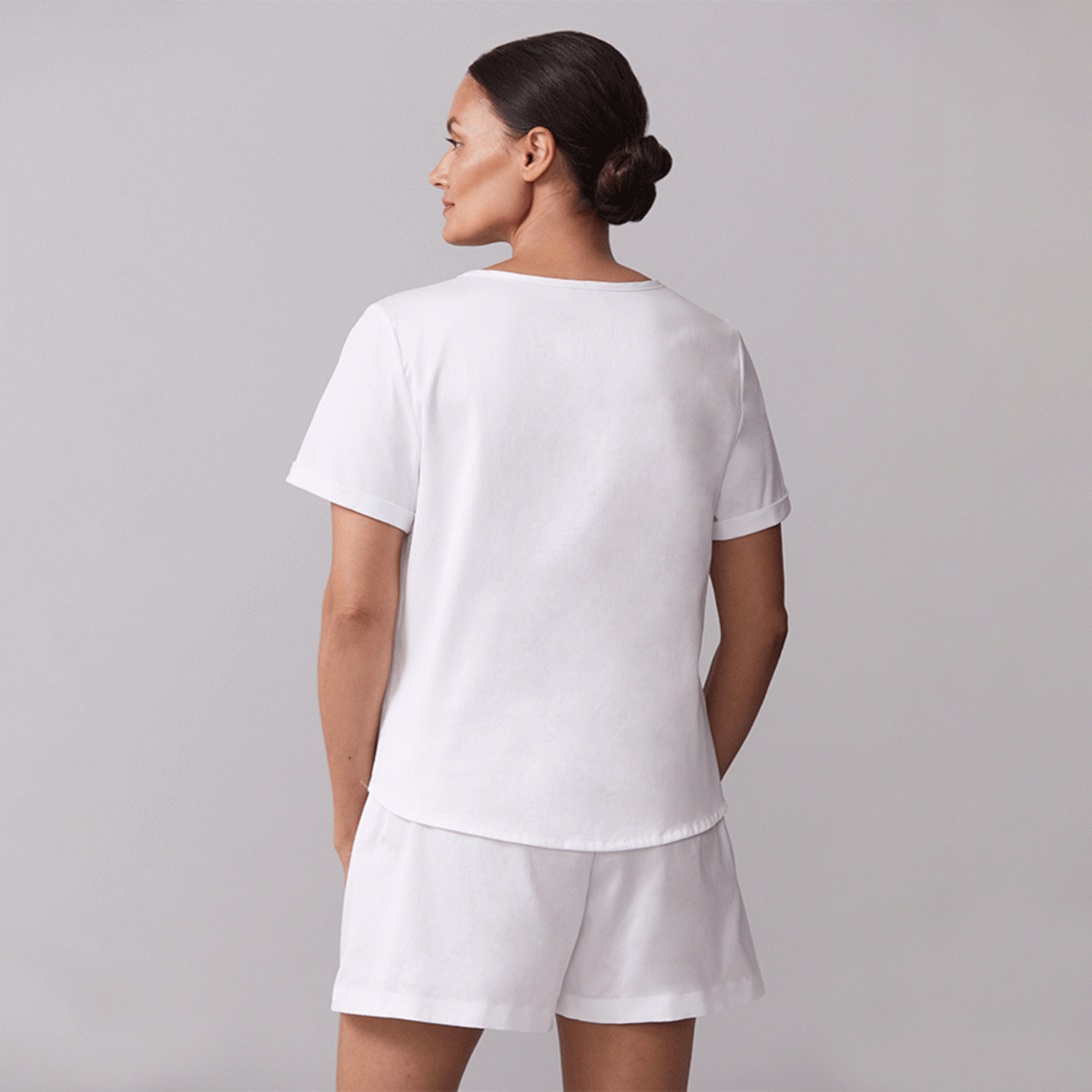 Back View of Model Wearing a White Sferra Caricia Short Sleeve Top