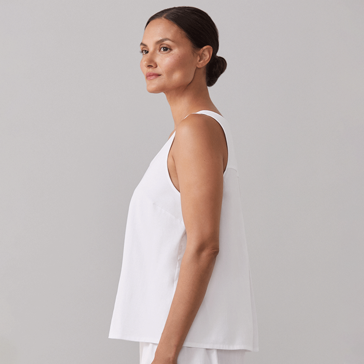 Side View of Model Wearing a White Sferra Caricia Swing Tank Top