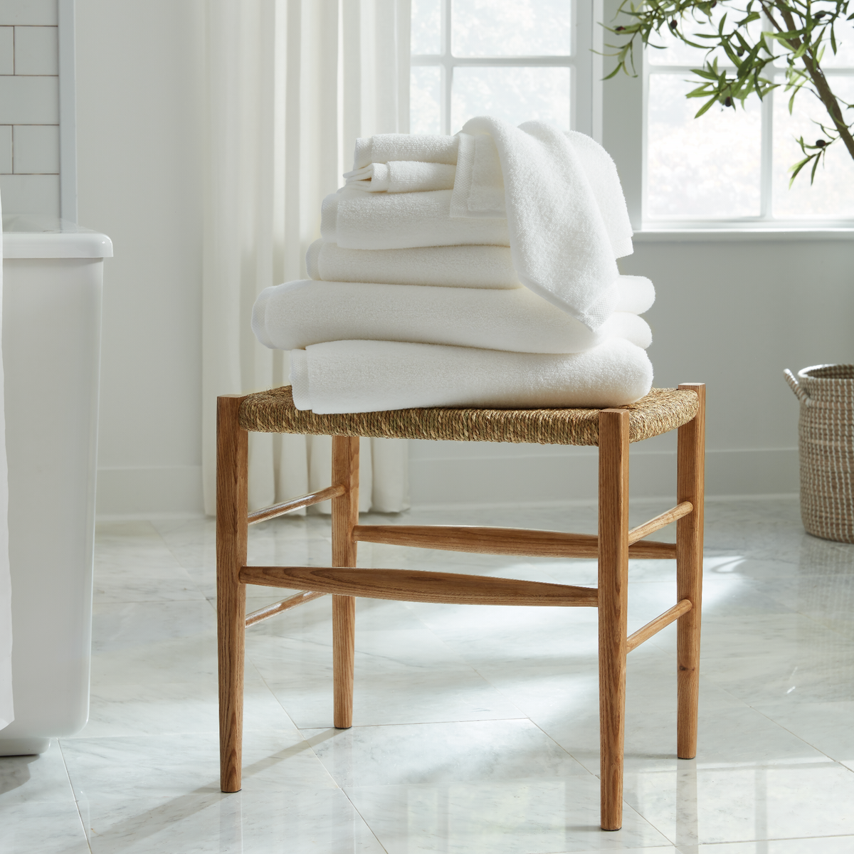 Stack of White Sferra Cielo Bath Towels on a Stool