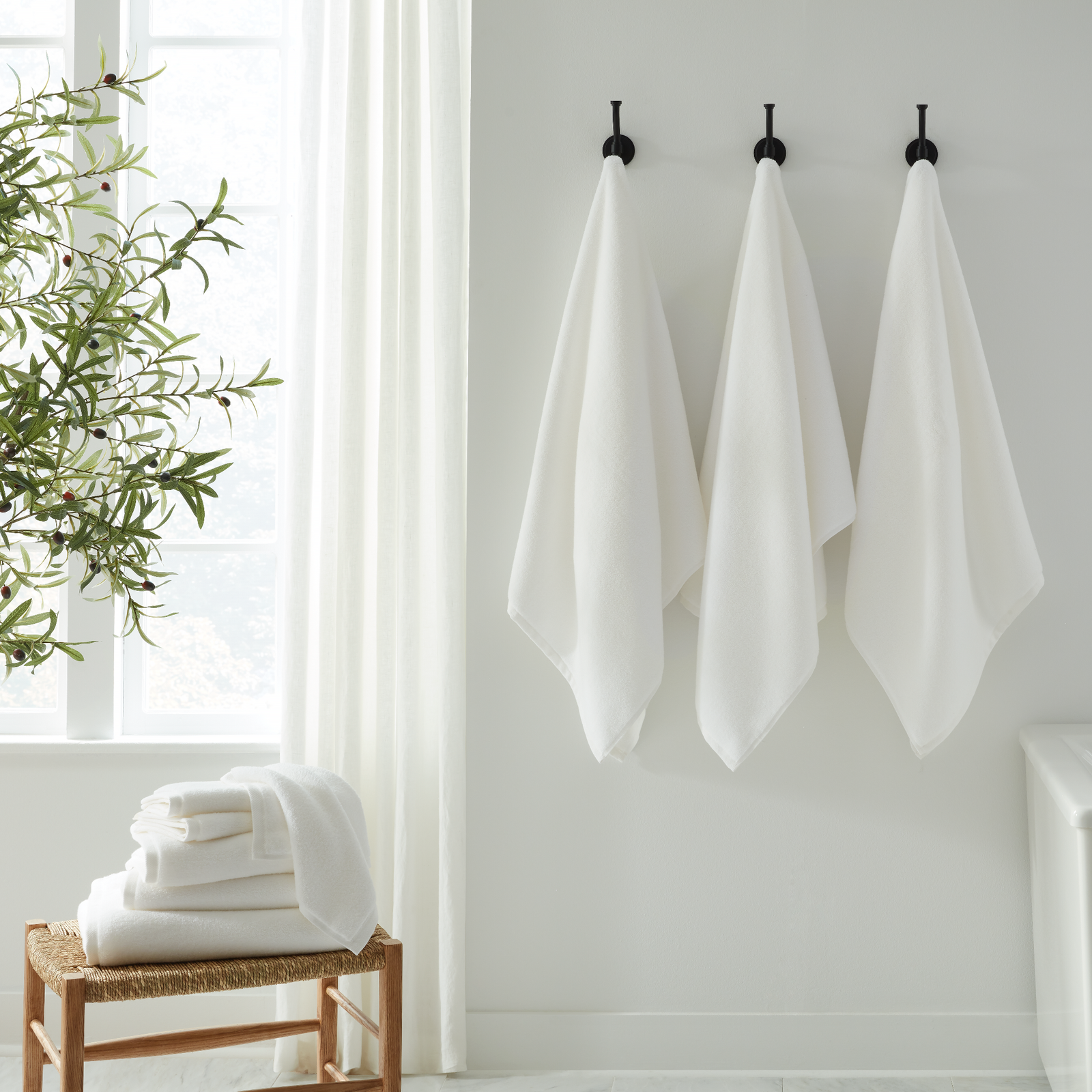 Set of White Sferra Cielo Bath Towels in a White Bathroom