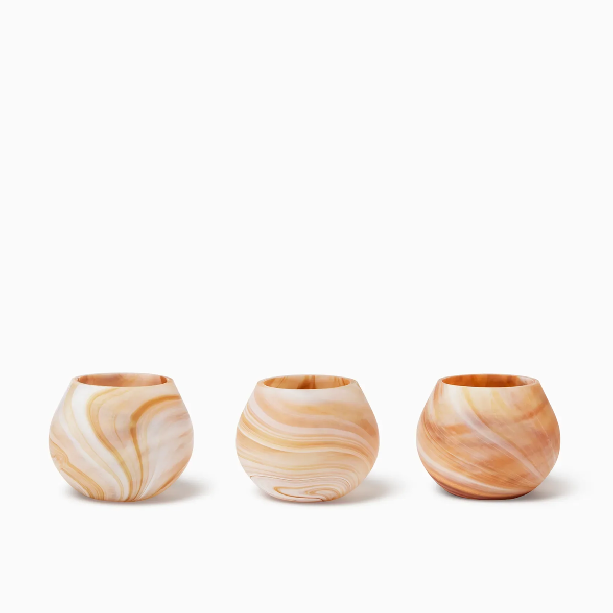 Three round, Almond Sferra Giove Marbled Votive Holders, set against a white background.