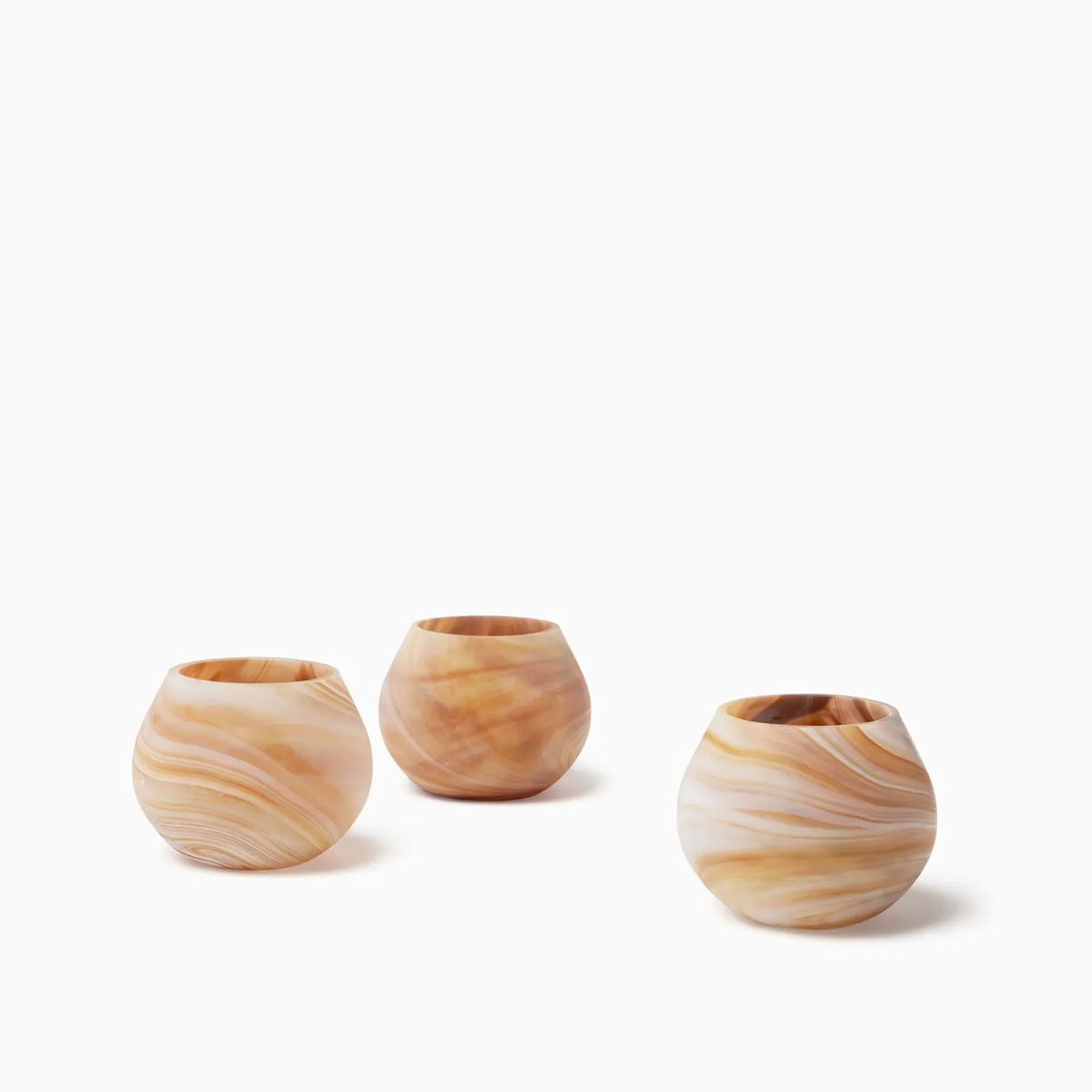 Three round, Almond Sferra Giove Marbled Votive Holders, perfect as bespoke glass accessories for your decor.