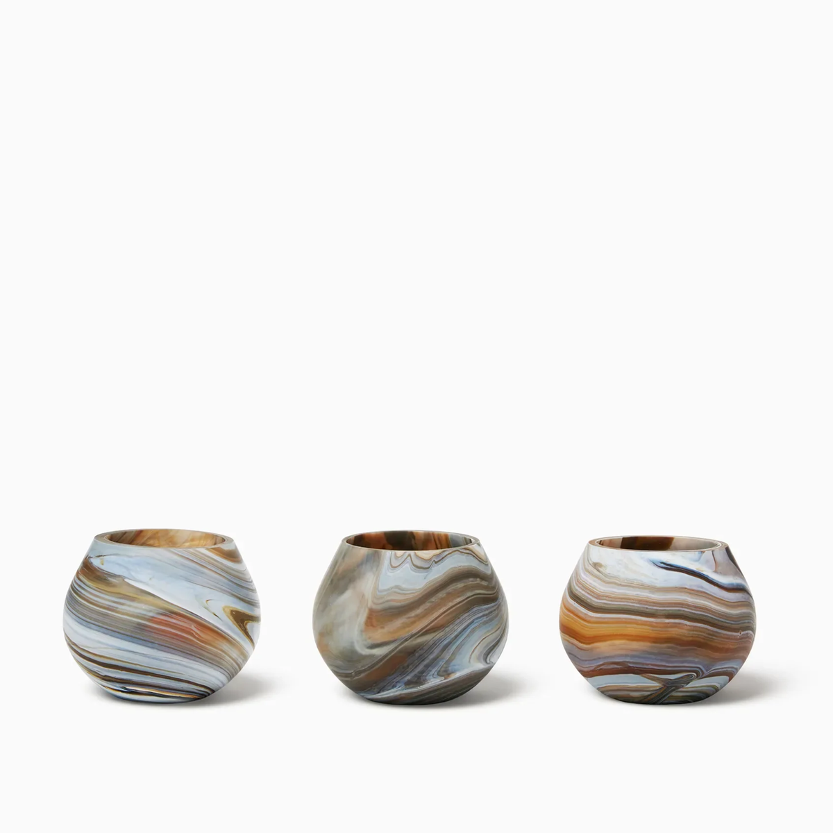 Three round, Bark Sferra Giove Marbled Votive Holders, set against a white background