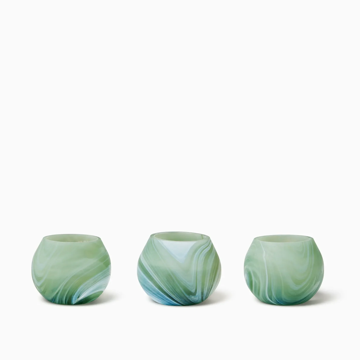 Three round, Clover Sferra Giove Marbled Votive Holders, set against a white background