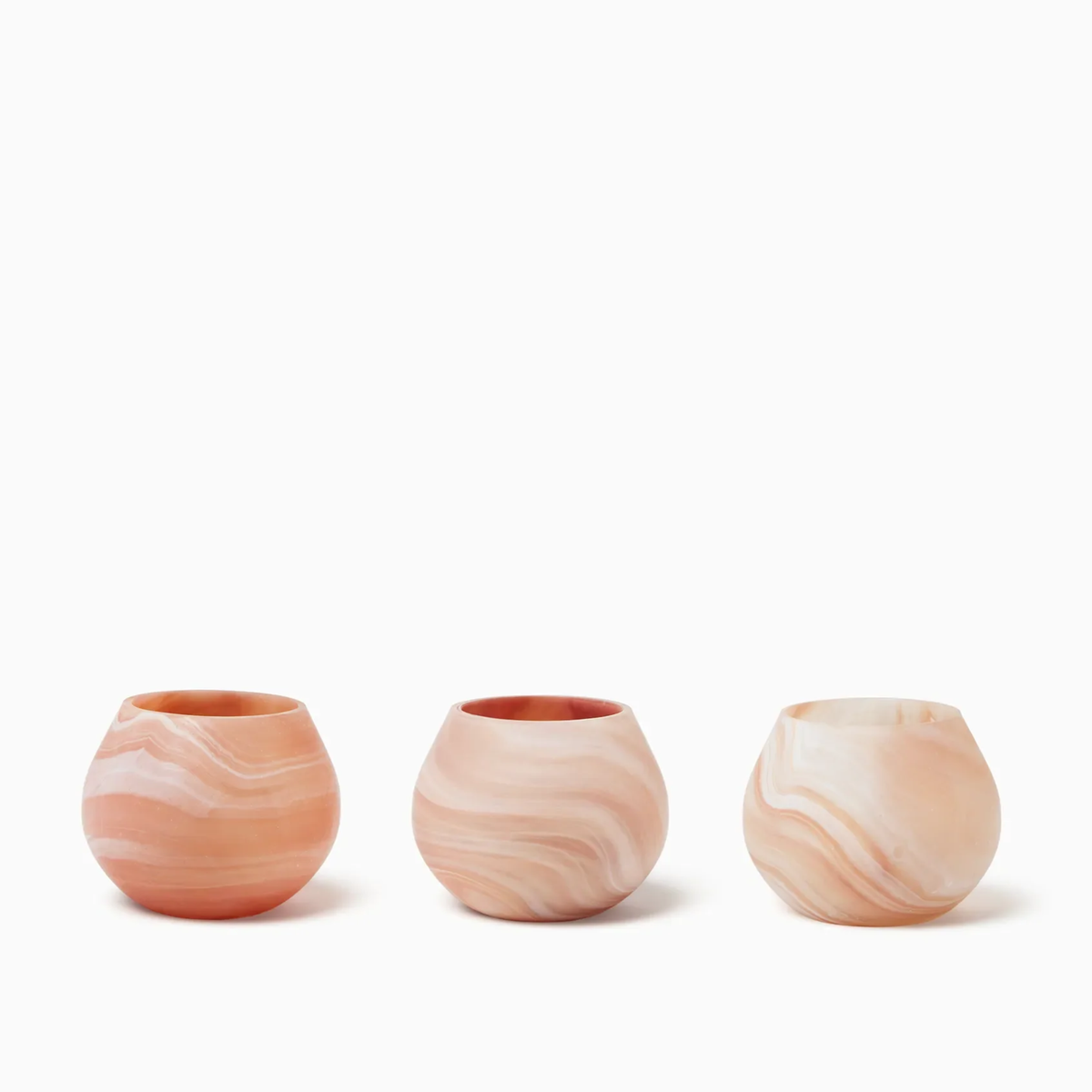 Three round, Paprika Sferra Giove Marbled Votive Holders, set against a white background