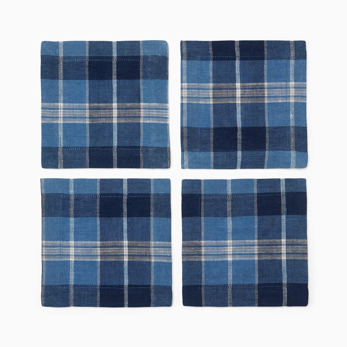 Four square plaid Sferra Masseria Cocktail Napkins in Cadet and Navy colors on a crisp white background
