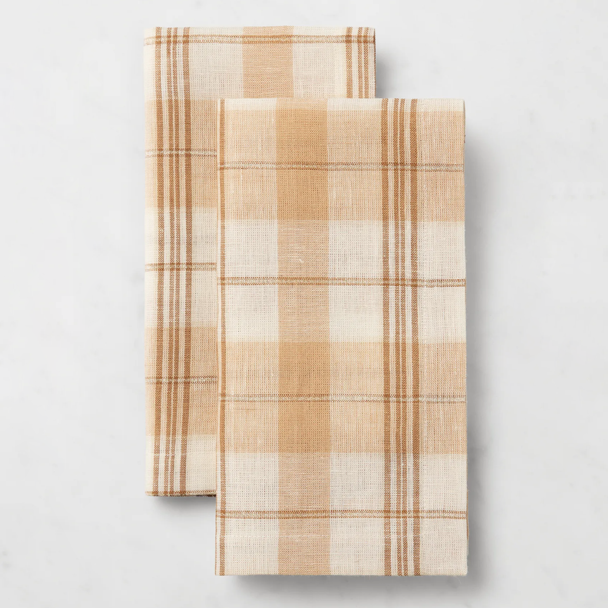 Two folded Sferra Masseria Dinner Napkins in Almond and Oyster colors rest side by side, perfect for autumnal table decor