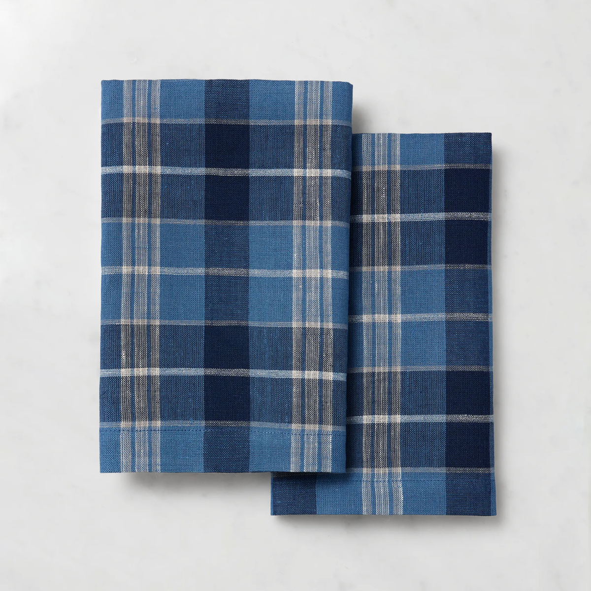 Two folded plaid Sferra Masseria Guest Towels in Cadet and Navy colors - add charm to your autumnal table decor.