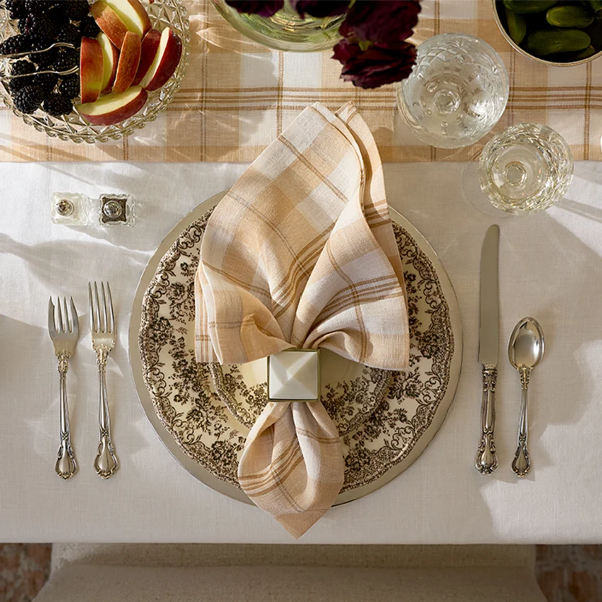 A table setting with patterned plate, crystal glasses, and Sferra Masseria Table Linens Lifestyle in Almond and Oyster colors